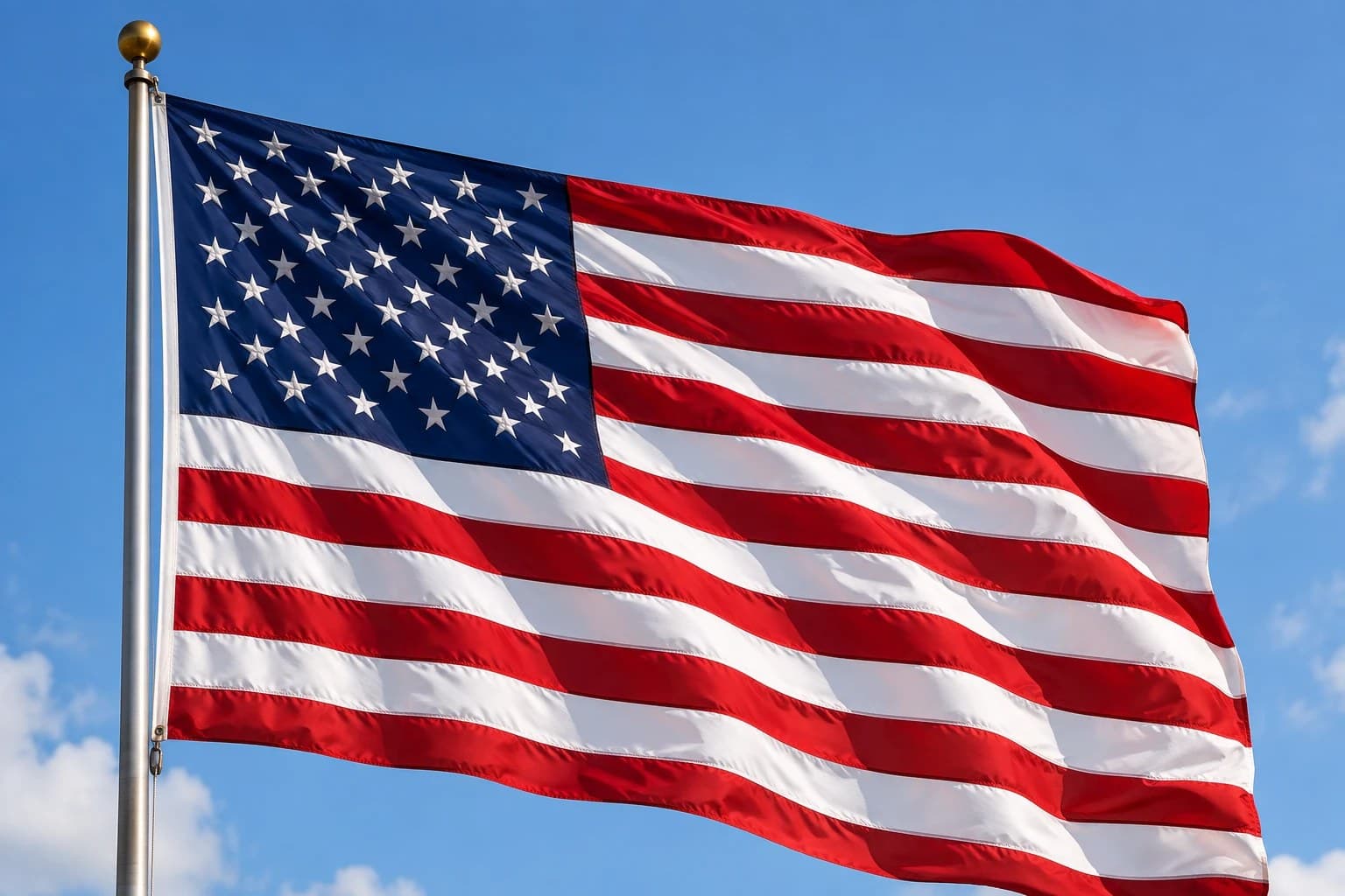 A United States flag flying against a clear sky.